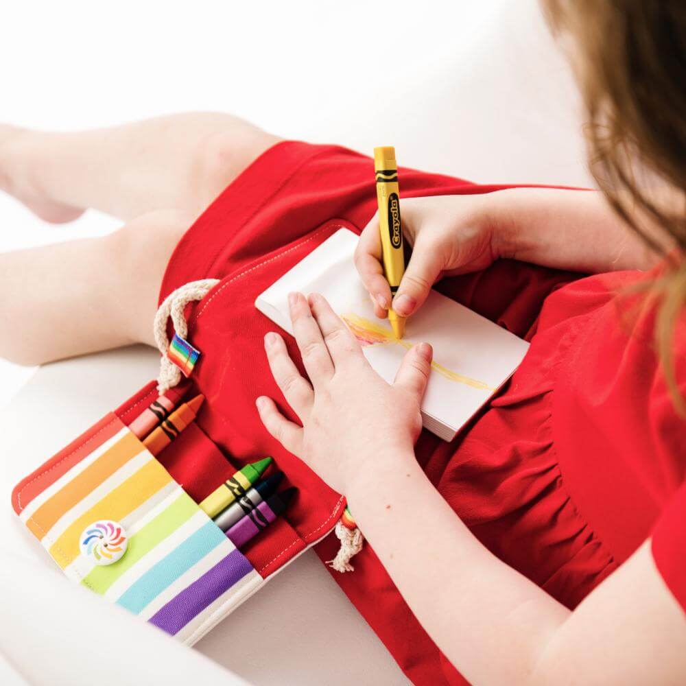 girl coloring with her crayon bag 