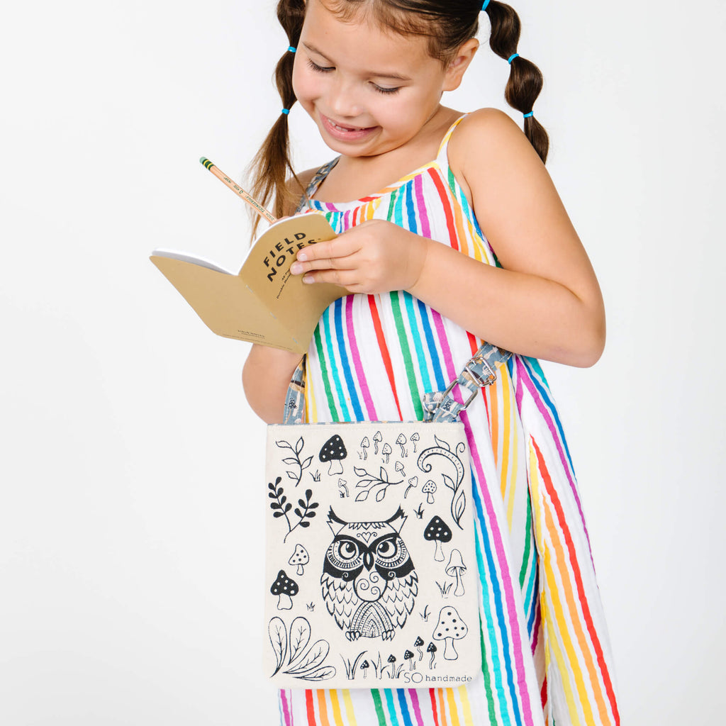 little girl and her nature bag with pad and pencil
