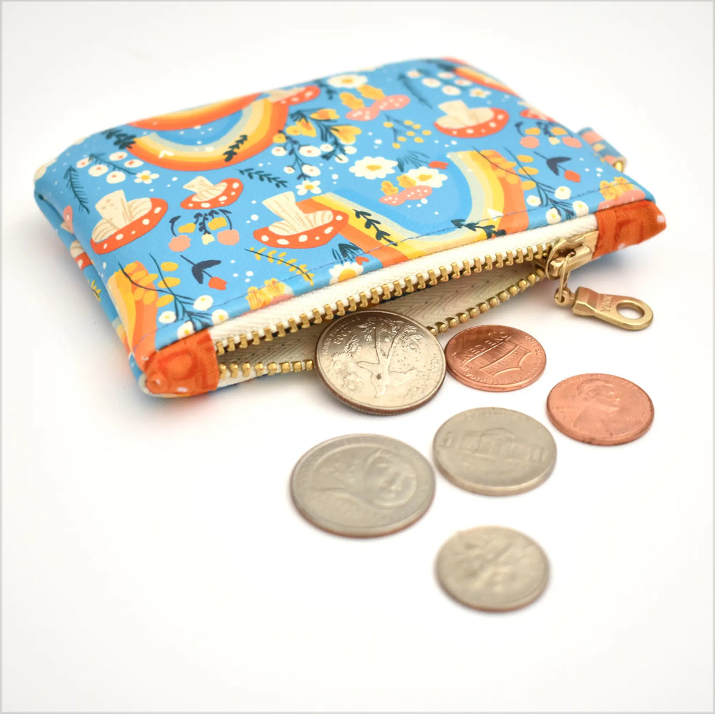 Colorful coin purse with zipper and coins on a white background