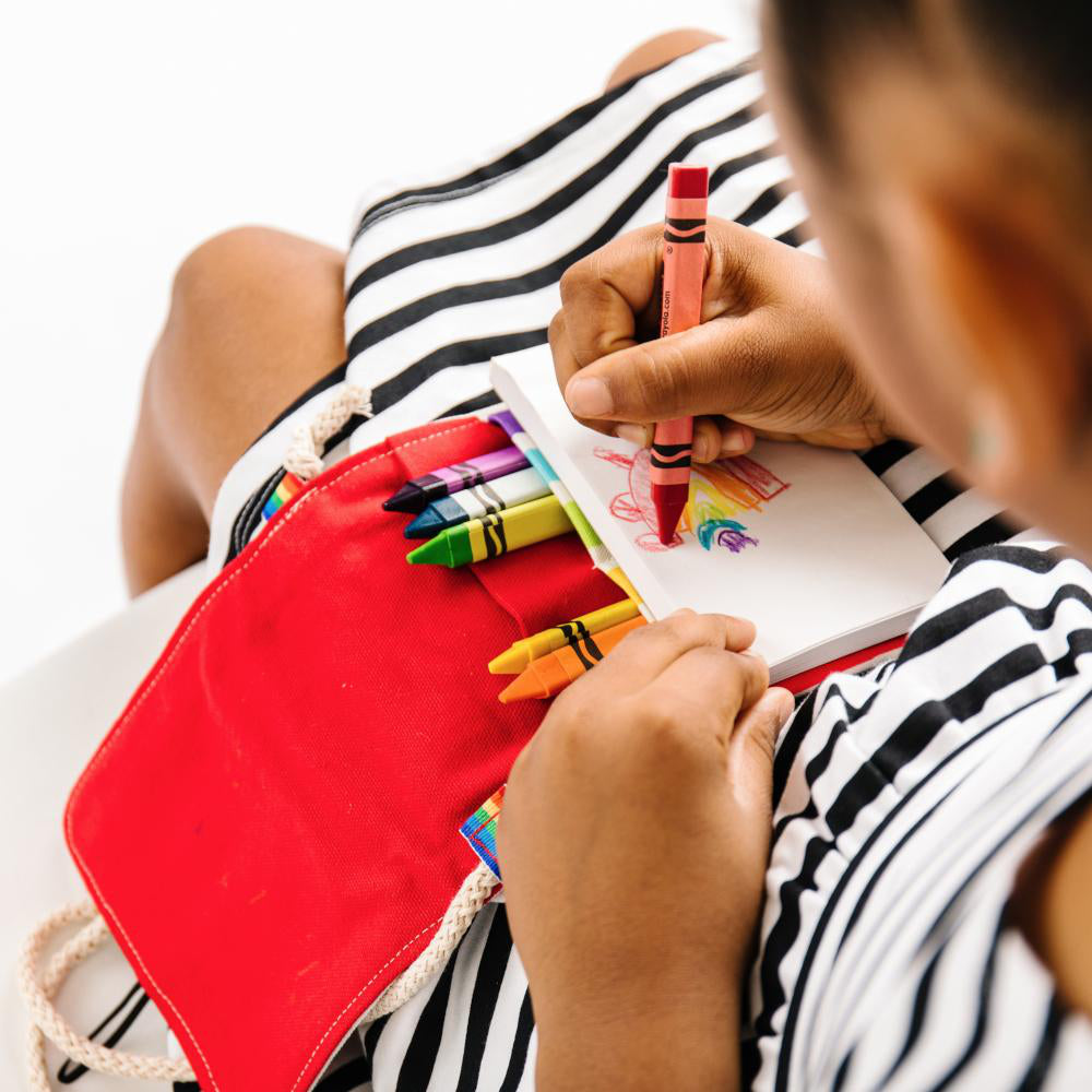 girl coloring in a notepad 