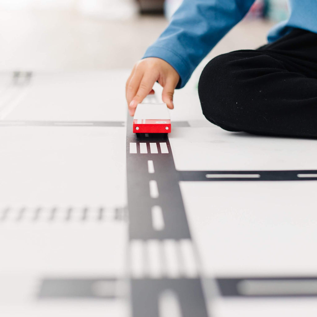 Toddler playing with toy car on Road tape