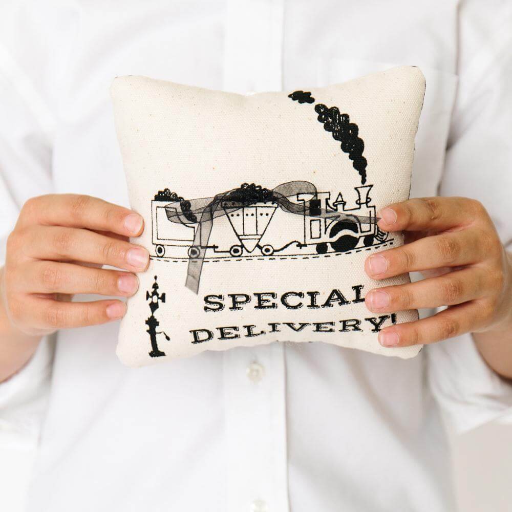 boy holding train ring bearer pillow
