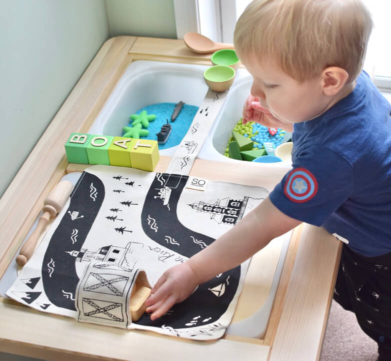 kid playing with river play mat