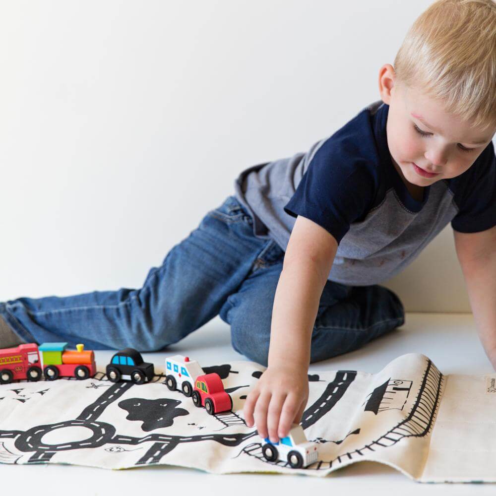 boy playing with toy train on playmate